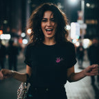 Black pocket tee with embroidered chest detail, model sportin' relaxed fit in urban setting.