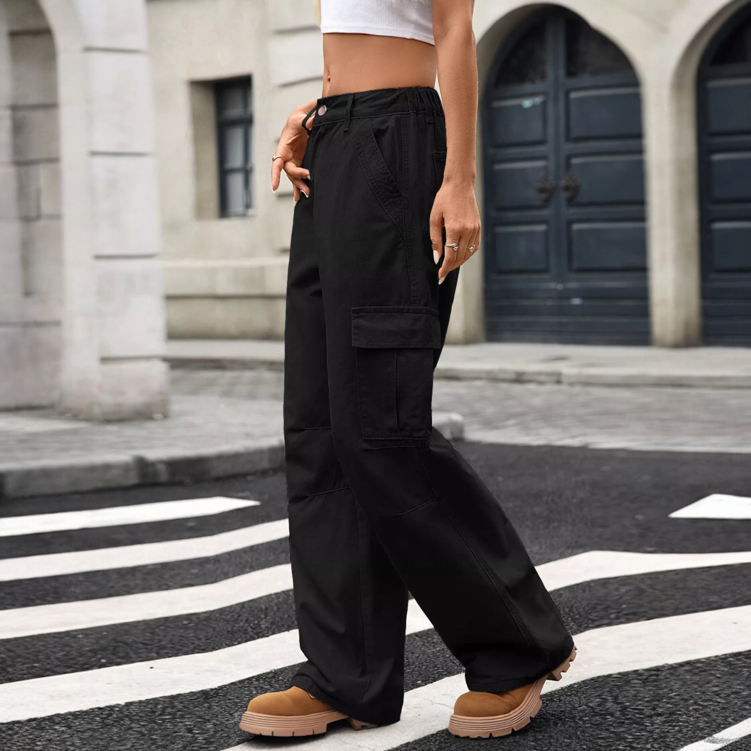 A bold matey sportin' black cargo pants with pockets, high waist, and a loose fit in an urban setting.
