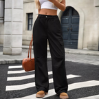 A bold lass in black cargo pants, high-waisted and pocketed, paired with a cropped top and tan footwear.