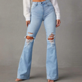 Light wash distressed flare jeans with rips at the knees, styled with a fitted top for a bold look.