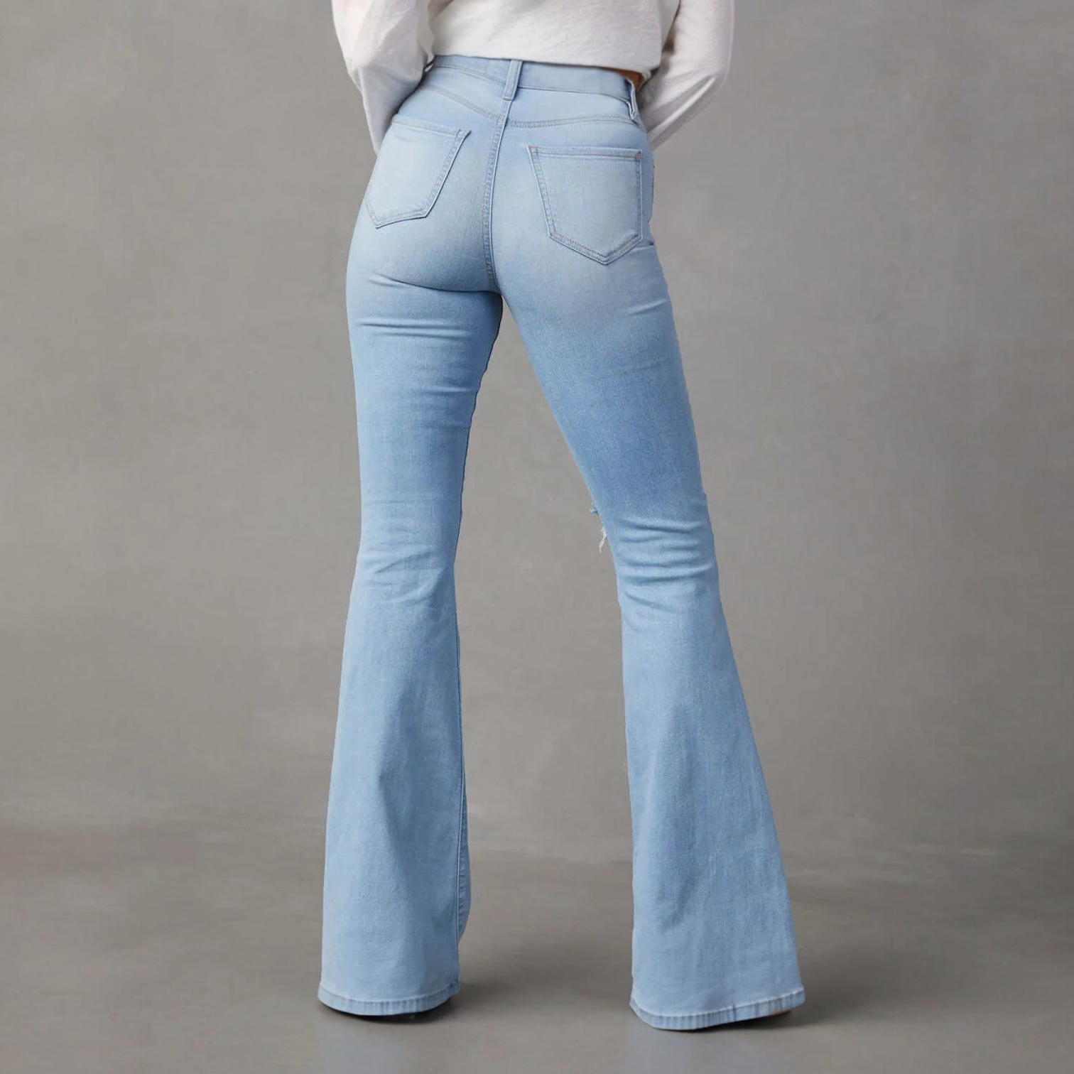 Light wash flared denim jeans with fitted waist and back pockets, perfect for bold fashion choices.