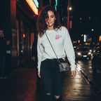 The Pretty Toxic Signature Long Sleeve shirt be sportin' bold graphics, worn by a lass in black jeans under the night sky.