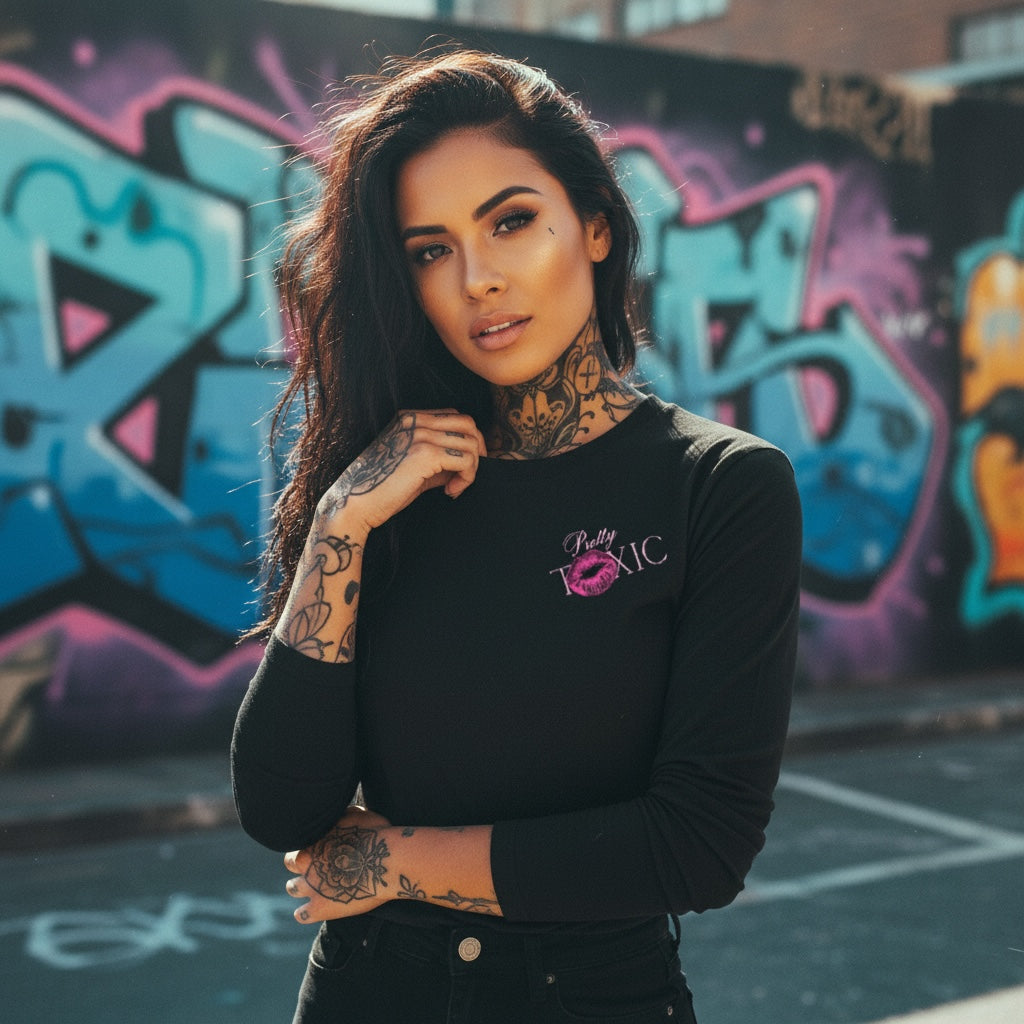 Black long sleeve shirt with front graphics, worn by a model against a graffiti backdrop. Perfect for bold lassies!