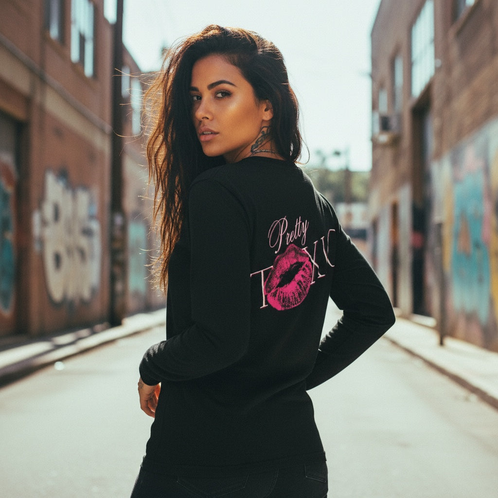 Black long sleeve shirt with front and back graphics, worn by a model in an urban setting.