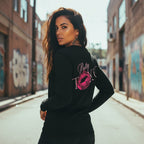 Black long sleeve shirt with front and back graphics, worn by a model in an urban setting.